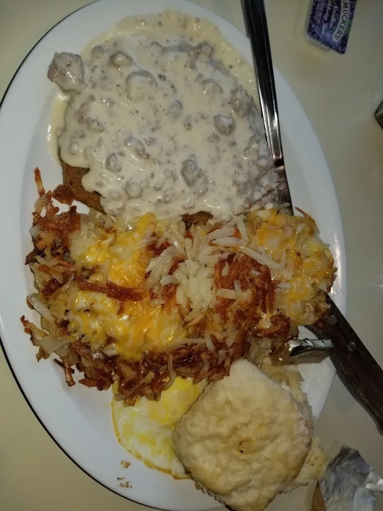 Chicken Fried Steak with Hash Browns and Eggs It Also Has Sausage Gravy on the Chicken Fried Steak